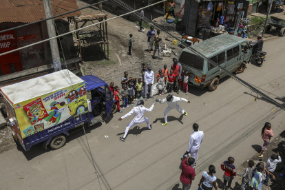 El esgrimista profesional keniano Isaac Mburu Wanyoike (d) entrena con miembros adolescentes del club Tsavora Fencing Mtaani en las calles del barrio marginal de Huruma en Mathare.