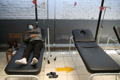 Un hombre con dengue yace en una camilla, recibiendo tratamientos paliativos.