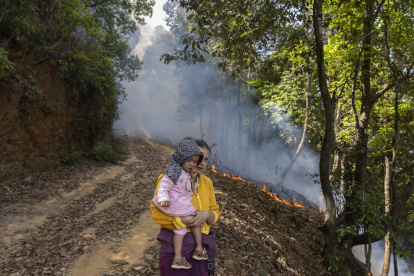 Una mujer local y un niño observan el incendio forestal cerca de la aldea de Godawari, en las afueras de Katmandú, Nepal, el 2 de mayo de 2024.