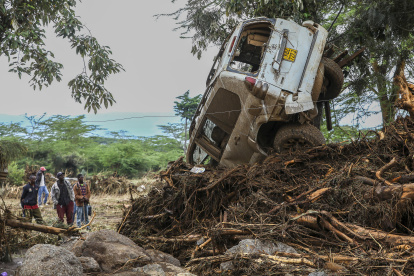 Nairobi. Personas observan un carro que fue arrastrado por un río.