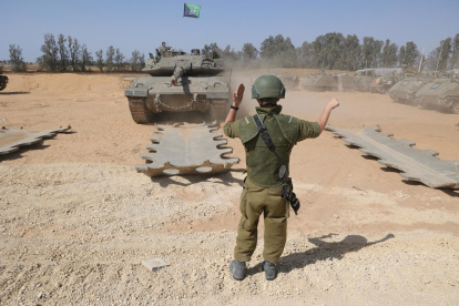 Vehículos blindados israelíes se reúnen a lo largo de la valla fronteriza con el sur de la Franja de Gaza.