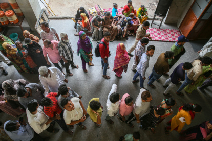 Los votantes indios esperan en una larga cola para emitir su voto en un colegio electoral durante la tercera fase de las elecciones generales en Ahmedabad, Gujarat, oeste de India, 07 de mayo de 2024.