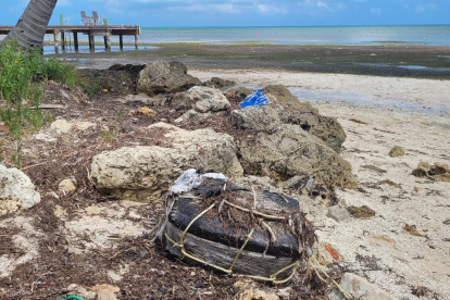 La bolsa plástica atada con cuerdas con los ladrillos de droga en el interior que fue hallada por un bañista este miércoles, en una playa sin especificar de los Cayos de Florida (EE. UU).