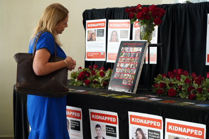 Una mujer observa las fotos de los secuestrados por Hamás el 7 de octubre pasado