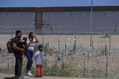 Una familia colombiana permanece en la linea divisoria entre México y EEUU este sábado, en la ciudad Juárez, en el estado de Chihuahua (México).