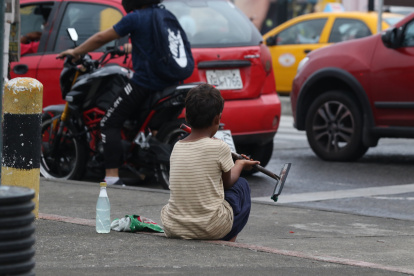 Un menor en edad escolar se dedica a limpiar parabrisas en una calle del centro de Guayaquil.