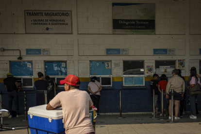 Decenas de hondureños pasan por la aduana de su país para ingresar a Guatemala en el puesto fronterizo de El Corinto.