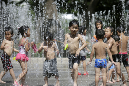 Tokio. Niños se refrescan en una fuente de la capital de Japón.