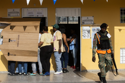 Votantes se protegen del sol en un centro de votación luego de una jornada de elecciones este domingo en Santo Domingo (República Dominicana). La tranquilidad y la ausencia de problemas fueron, junto al calor, los otros protagonistas de los comicios de este domingo en República Dominicana, en medio de un amplio dispositivo de seguridad desplegado en torno y dentro de los centros de votación para que los dominicanos eligieran a su presidente, su vicepresidente y sus legisladores para los próximos cuatro años. EFE/ Orlando Barría