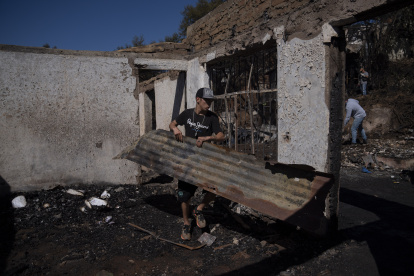 Personas retiran escombros este jueves de las viviendas destruidas por el incendio que afectó al Cerro Cordillera en Valparaíso (Chile).