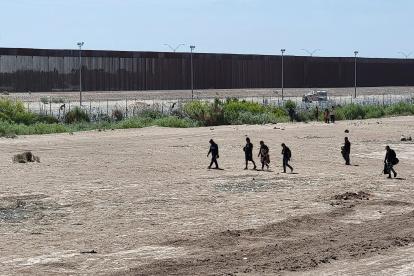 Migrantes permanecen en la línea divisoria entre México y EEUU este jueves, en Ciudad Juárez, en el estado de Chihuahua (México).