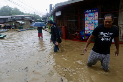 Aldeanos caminan en la ciudad de Pagsanjan, afectada por las inundaciones, provincia de Laguna, Filipinas, el 26 de mayo de 2024.