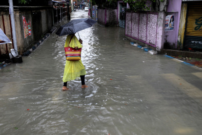 Una mujer cruza por un sector de Nueva Delhi completamente inundada.