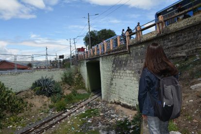 La ciudadana Trinidad Supe observa los rieles por donde antes circulaban los trenes, que actualmente se encuentran llenos de basura y maleza.