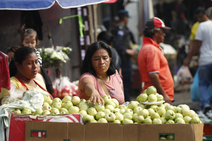 Una vendedora ambulante de frutas ofrece sus productos este miércoles en el centro de San Salvador.