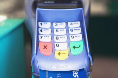 Pago. Una persona cancela una factura con tarjeta de crédito.