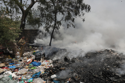 Un bombero apaga un fuego en Nueva Delhi, India.