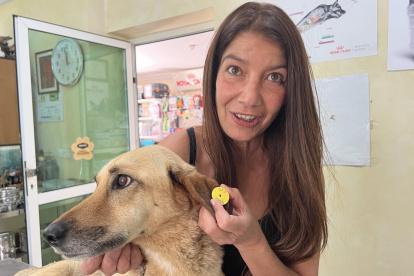 Salima Kadaoui posa en el veterinario junto a una perra callejera enferma en Tánger (Marruecos).