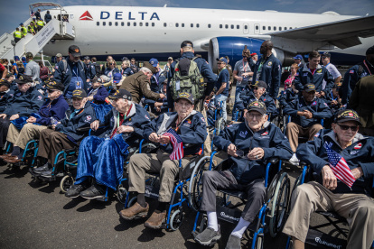 Veteranos estadounidenses de la Segunda Guerra Mundial sentados en sillas de ruedas a su llegada al aeropuerto de Deauville-Trouville.