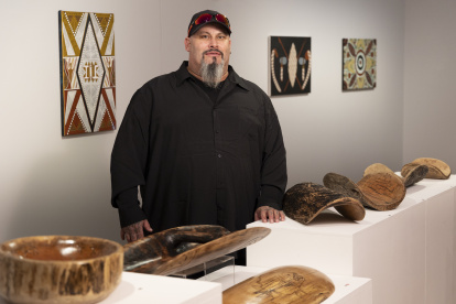Timothy, de los Wiradjuri, posa junto a varias piezas de arte.