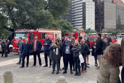 Decenas de personas observan los momentos en el que el "influencer" polaco Marcin Banot, trepó 25 pisos de un rascacielos de 125 metros de alto en el centro de Buenos Aires.