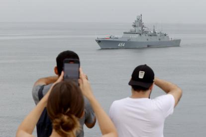 Personas observan la llegada de uno de los barcos pertenecientes a la flotilla de la Marina de Guerra de Rusia.
