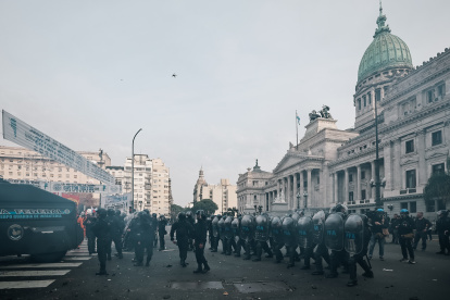 Policías intentan proteger de los manifestantes el Senado argentino, donde se aprobó la esperada ley Bases.