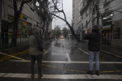 Un hombre observa un árbol caído debido a las fuertes lluvias, este jueves en Valparaído (Chile).