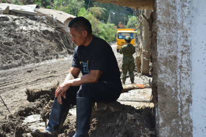 Luis Chango, sentado frente a la casa dónde murieron cuatro integrantes de su familia.