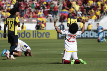 Angelo Preciado (i) camina cabizbajo ante el festejo de un venezolano.