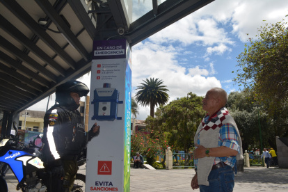 Atención. Un policía explica a un ciudadano cómo pedir ayuda a través de la alarma ubicada en un parque.