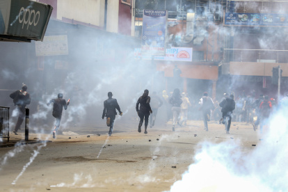 Los manifestantes reaccionan cuando la policía dispara gases lacrimógenos para dispersarlos durante una nueva protesta dos días después de las mortales protestas contra los aumentos de impuestos en Nairobi. 27 de junio de 2024.