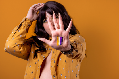 Persona mostrando la bandera del género no binario.