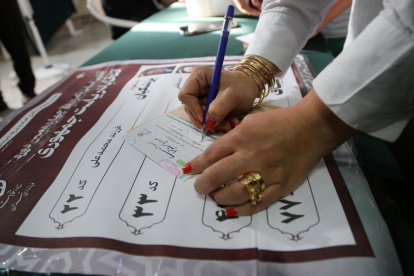 Una mujer iraní rellena la papeleta de voto en un colegio electoral durante las elecciones presidenciales, en Teherán, Irán, el 28 de junio de 2024.