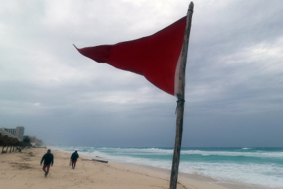una bandera roja en la playa que indica oleaje agitado y fuertes corrientes debido a la proximidad de la tormenta tropical "Beryl", en Cancún.
