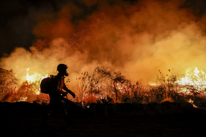 Un bombero trabaja en la extinción de un incendio este domingo en la ciudad de Corumbá (Brasil).