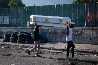Puerto Príncipe. Dos hombres cargan ataúd por una calle de esta capital.