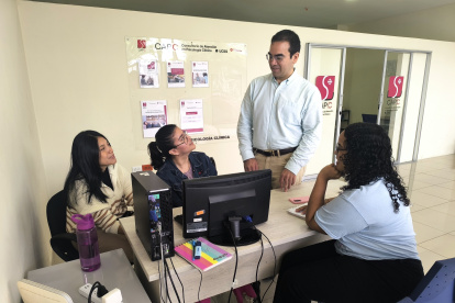 Rodolfo Rojas, director del centro de atención psicológica de la UCSG, junto a estudiantes de pregrado que colaboran en la entidad.