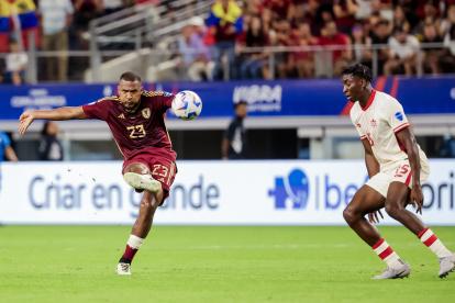 José Salomón Rondón (Izq.) de Venezuela anota el gol del empate 1-1 contra Moise Lumpungu (Der.) de Canadá durante la segunda mitad de la Copa América 2024.