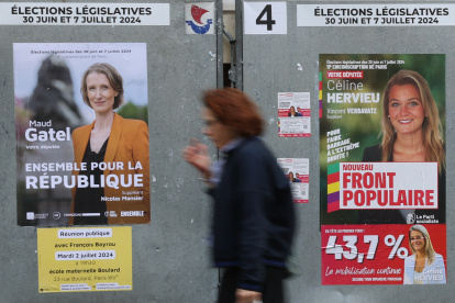 Una mujer pasa por un cartel de los candidatos (R) del Nouveau Front Populaire "el Nuevo frente Popular" para las elecciones parlamentarias en París, Francia, 04 de julio de 2024. La segunda vuelta del Las elecciones parlamentarias francesas se celebrarán el 7 de julio de 2024. (Elecciones, Fran
