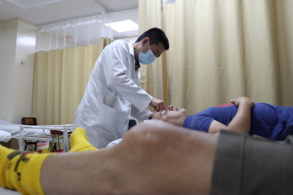 Bruce Chunsik Im es acupunturista y neurocirujano; su asistente recibe primero al paciente y le pregunta síntomas y de ser el caso pide historias clínicas.