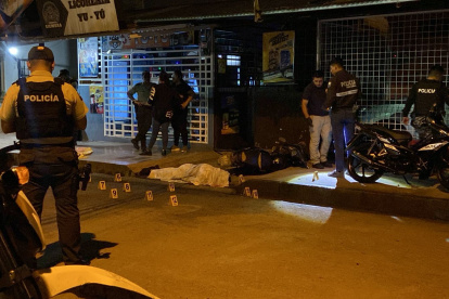 Policías y curiosos observan el lugar donde ocurrió el crimen.