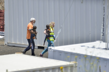 El Hierro (España). Miembros de los Servicios de emergencias llevan dos niños que llegaron en una patera.