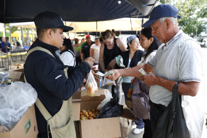 Un hombre compra en uno de los mercados alternativos de frutas y verduras lanzados por el gobierno, en el parque "Daniel Hernández" en Santa Tecla (El Salvador).