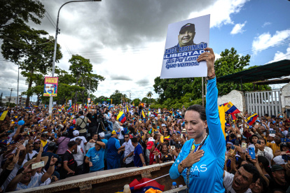 La líder antichavista María Corina Machado sostiene la imagen de Angel Aristimuño, presidente del partido Un Nuevo Tiempo en Monagas, durante una caravana para promover el voto hacia el candidato presidencial de la principal alianza opositora de Venezuela, Edmundo González Urrutia, de cara a las elecciones presidenciales, este sábado en Maturín (Venezuela).