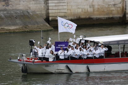 La selección de refugiados bajo la bandera de las olimpiadas desfilan por el río Sena, durante la ceremonia de inauguración de los Juegos Olímpicos de París 2024, este viernes en la capital francesa.