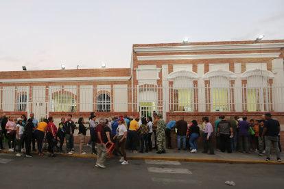 Ciudadanos esperan para votar este domingo, afuera de un centro de votación en Caracas (Venezuela).