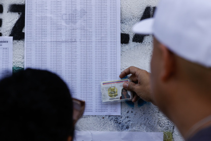 Un ciudadano venezolano busca su mesa de votación durante la jornada de elecciones presidenciales de Venezuela este domingo, en Caracas (Venezuela).