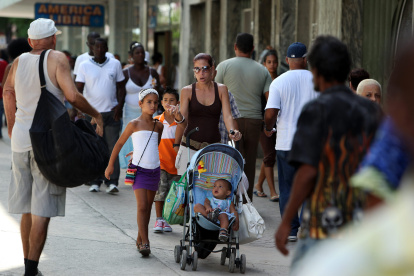 Una mujer que camina acompañada de sus niños por una calle de La Habana (Cuba).