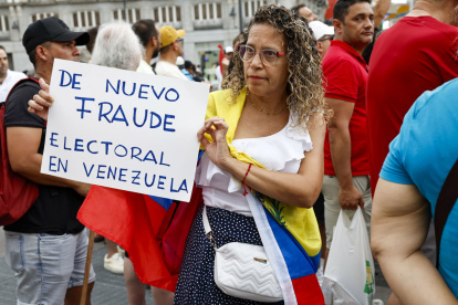 Una mujer sostiene una pancarta en la manifestación convocada por la oposición venezolana un día después de las elecciones en el país, este lunes en Madrid.